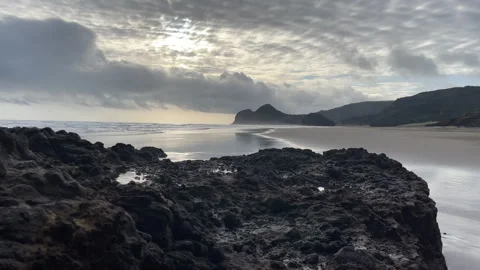 Silvery waves crashing on an empty surf beach with a moody sky Stock Footage 284774605