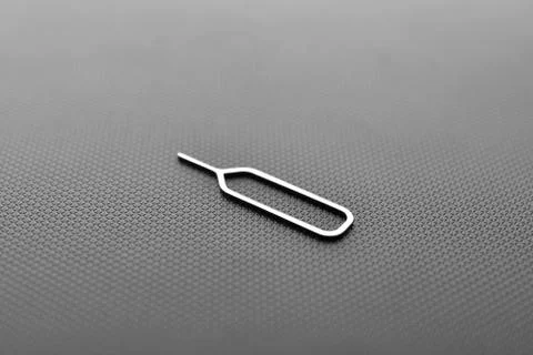 Sim card ejector tool on black texture background Foto stock