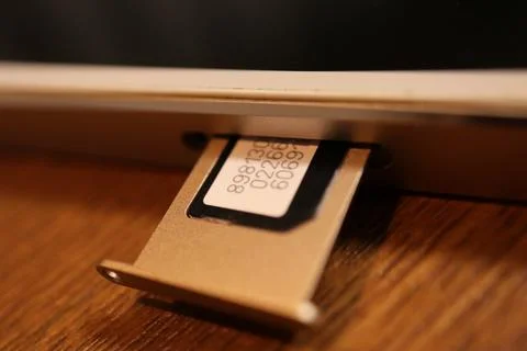 SIM card inserted in a champagne gold smartphone tray showing identificatio.. Stock Photos