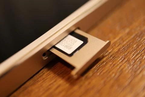 SIM card inserted into a mobile smartphone device showing the open tray and.. Stock Photos