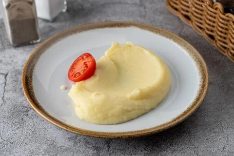 Simple all-purpose garnish: mashed potato puree with a slice of ripe tomato Stock Photos