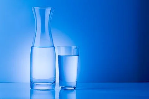 A simple and clean image featuring a half-filled glass of water against a vib 스톡 사진