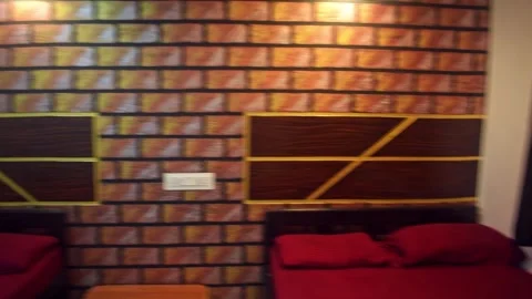 A simple and cozy bedroom with a brick wall, two beds, and comfortable beddin Stock Footage 341347066