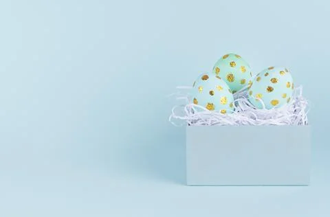 Simple and minimal easter background - easter eggs with golden dots in gift b Stock Photos
