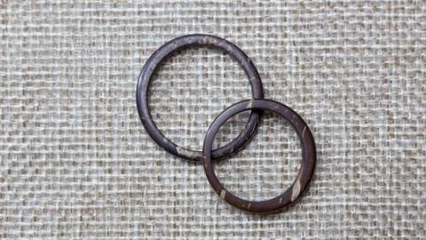 Simple and plain pair of handmade coconut rings in burlap background. Artisan Stock Photos