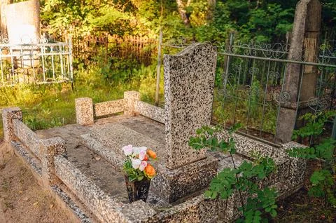 Simple anonymous tombstone without inscriptions on a quiet grassy plot in a.. 写真素材