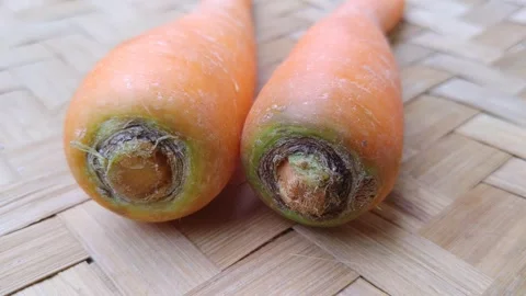 Simple arrangement of two fresh carrots on an Asian bamboo mat Video stock 344089144
