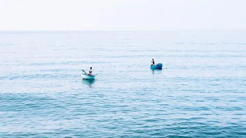 Simple background Calm dark blue sea fishing boats alone white pale Spindrift Stock Photos