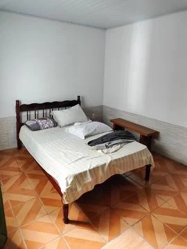 Simple bed with clothes on it Stock Photos