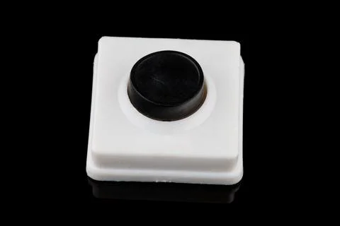 Simple black button press close-up on a black background Stock Photos