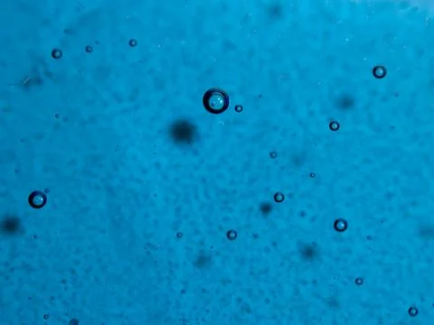 Simple blue glass texture background with embedded air bubbles. Stock Photos