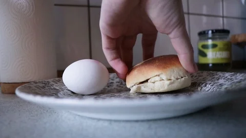 Simple breakfast, bread and an egg on a plat, and bread getting buttered. Vídeos de archivo 123428159