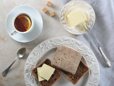 Simple Breakfast - lemon tea and rye bread with butter Stock Photos