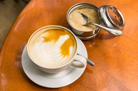 Simple cappuccino on a brown round table Stock Photos