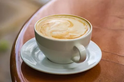 Simple cappuccino on a brown round table Stock Photos