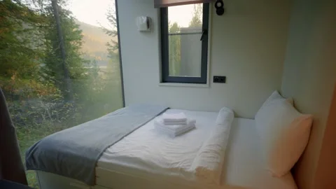 Simple, clean room with big window framing lush green trees Vídeos de archivo 345812344