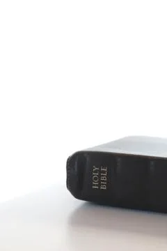 Simple Closed Holy Bible on a White Table and a White Background Stock Photos