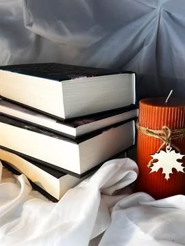A simple composition of many books with candle, stack or pile of books on whi Stock Photos