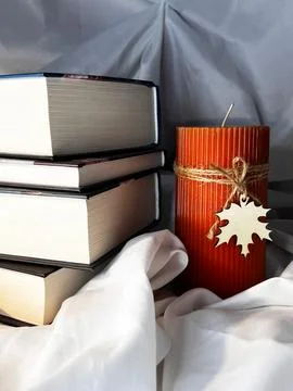 A simple composition of many books with candle, stack or pile of books on whi Stock Photos