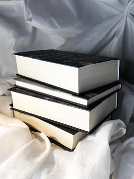 A simple composition of many books, stack or pile of books on white textile.. Stock Photos