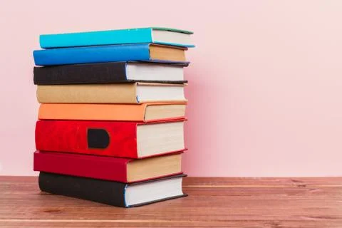 A simple composition of many hardback books, raw books on a wooden table and  Stock Photos