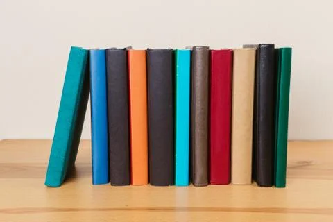 Simple composition of many hardback books, raw of books on wooden table and l Stock Photos