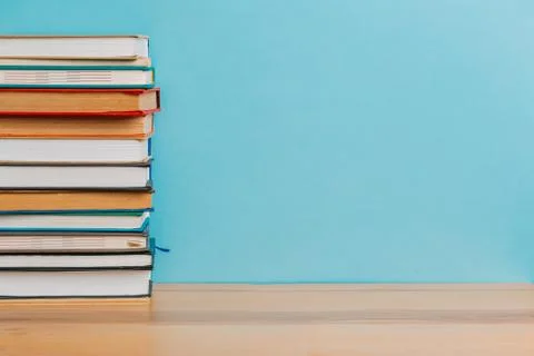 A simple composition of many hardback books, raw books on a wooden table and  Stock Photos