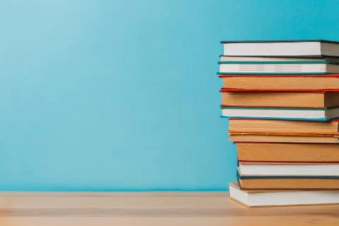 A simple composition of many hardback books, raw books on a wooden table and  Stock Photos