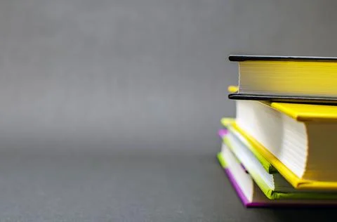 A simple composition of many hardback books on a black background. Back to Stock Photos