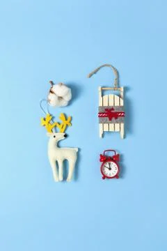 Simple creative Christmas composition. Cotton box, deer, wooden sled, alarm c Stock Photos