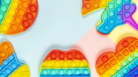 Simple Dimple touch multi-colored toy on pastel multi-colored background with a Stock Photos