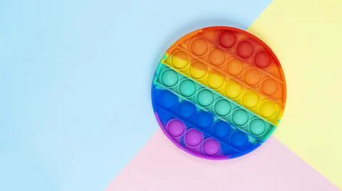 Simple Dimple touch multi-colored toy in the form of a circle on a colored Stock Photos