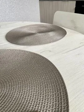 A simple dining setting features two round, beige woven placemats Stock Photos