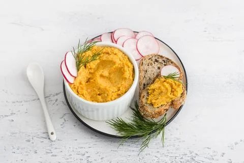 Simple egg pate or dip with carrots and fried onions in a white bowl decorated Stock Photos