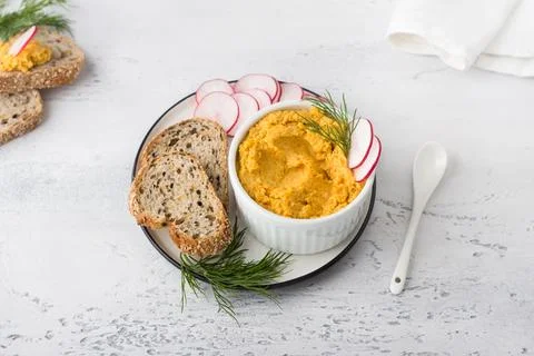 Simple egg pate or dip with carrots and fried onions in a white bowl Stock Photos