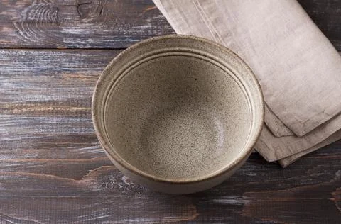 Simple empty beige craft ceramic bowl on wooden table, rustic style, mockup, for Stock Photos
