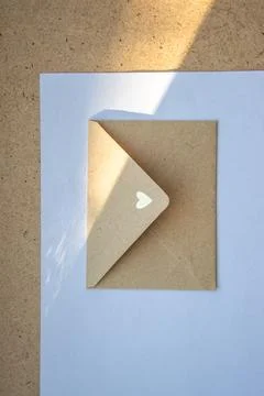 A simple envelope with a small heart on the corner is partially opened, resti Stock Photos