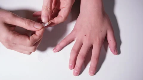 Simple first aid concept. Hands seal the wound with a medical plaster. Small Stock Footage 164435128