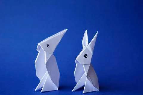 Simple flat lay out. two White rabbits paper origami on clear background with Foto stock