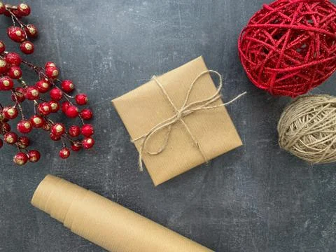 Simple gift box wrapped in craft paper on wooden background. Stock Photos