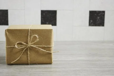 Simple Gift Box Wrapped in Kraft Paper with Twine on Wooden Surface for Occasion Stock Photos