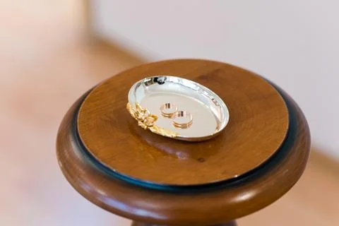 Simple gold wedding rings on a silver plate Stock Photos