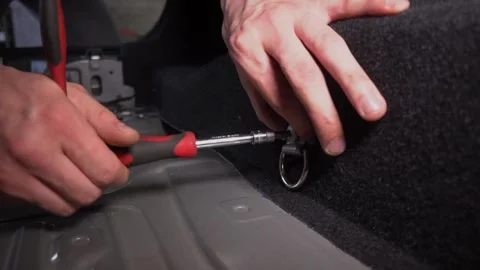 A Simple Guide to Installing a Cargo TieDown Hook in Various Vehicles for Stock Footage 311367551