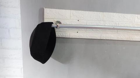 A simple hat hanging on a clothes hanger in a bedroom Stock Photos