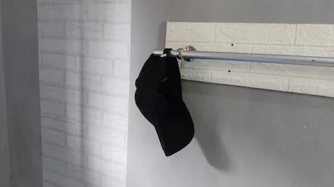 A simple hat hanging on a clothes hanger in a bedroom Stock Photos