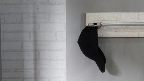 A simple hat hanging on a clothes hanger in a bedroom Foto stock
