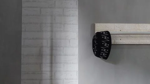 A simple hat hanging on a clothes hanger in a bedroom Stock Photos