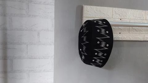 A simple hat hanging on a clothes hanger in a bedroom Stock Photos