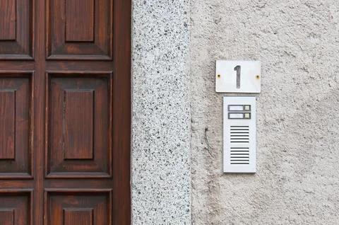 Simple intercom system next to a wooden door Stock Photos
