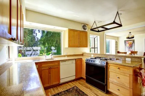 Simple kitchen interior with wooden cabinets and granite tops Stock Photos